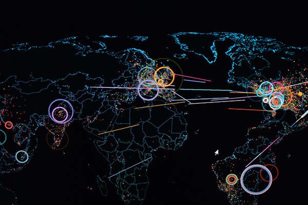 Detailed image of a digital map of the world on a computer screen with colorful lines and markers highlighting areas in the world experiencing a cyber attack. 